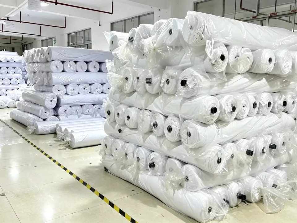 Warehouse stocked with rolls of white sport fabric